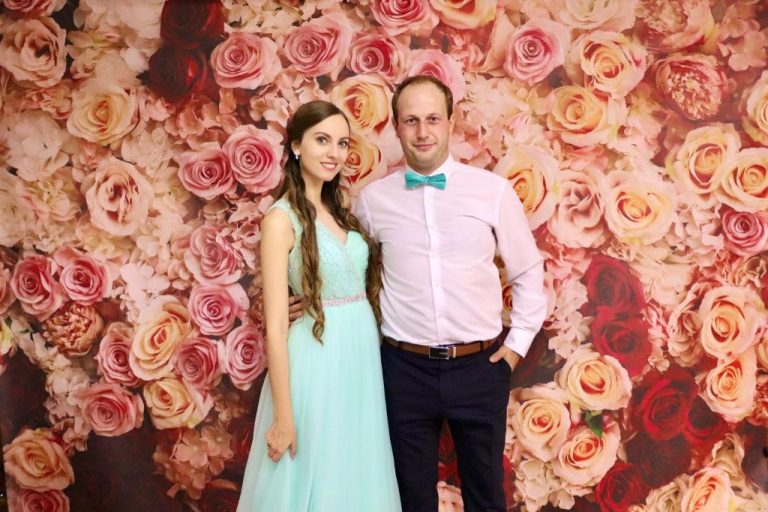 Mladý pár v spoločenských šatách pred kvetinovým vynilovým fotopozadím rozmeru 290x230cm